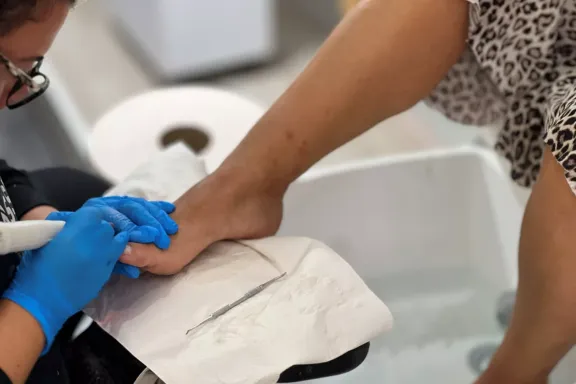 Adriana trabajando con un torno durante un tratamiento de pedicura