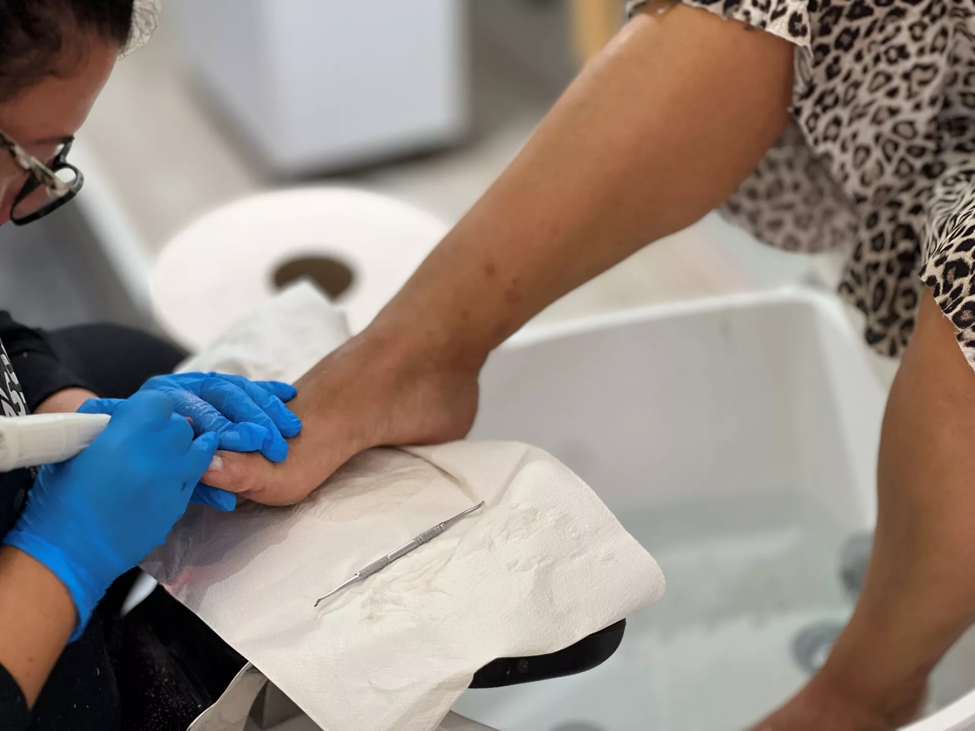 Adriana trabajando con un torno durante un tratamiento de pedicura